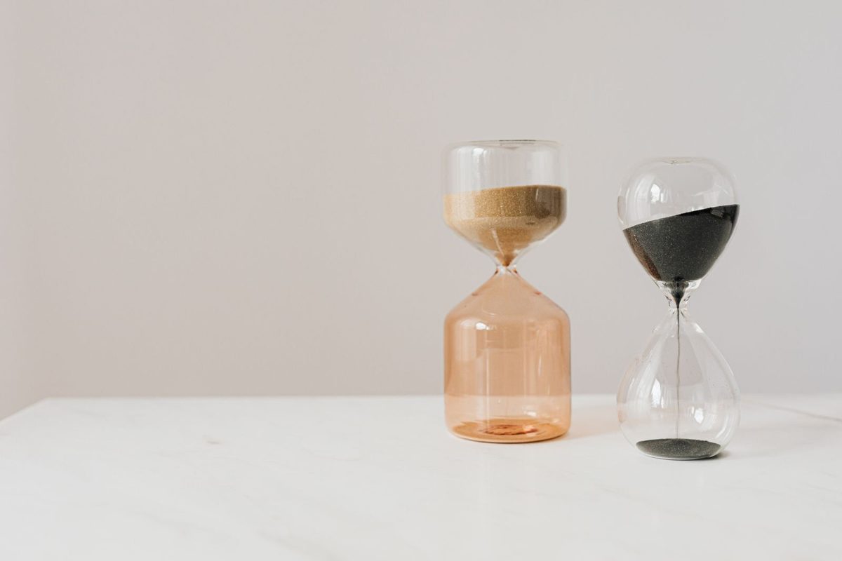 Dos relojes de arena sobre una mesa blanca