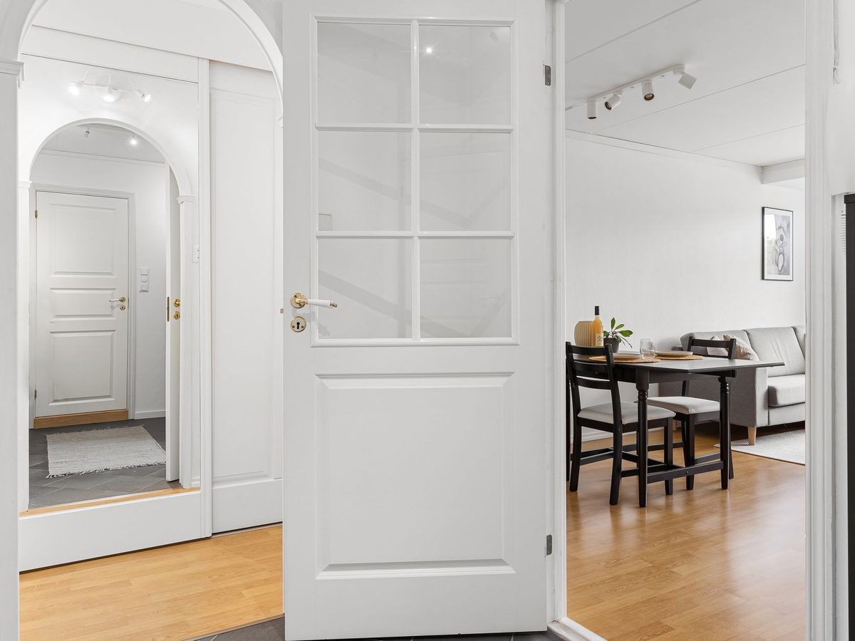 Una puerta blanca abierta en una casa luminosa