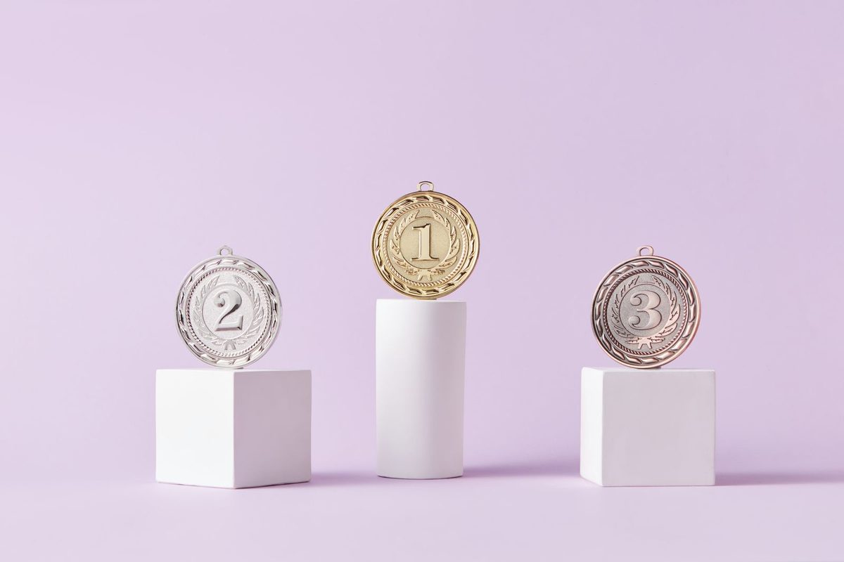 Medallas de oro, plata y bronce sobre pedestales blancos