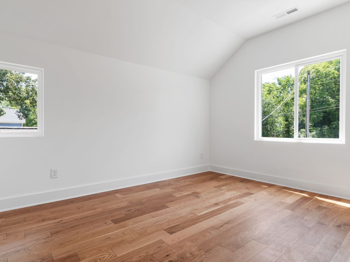 Una habitación vacía y luminosa, con dos ventanas